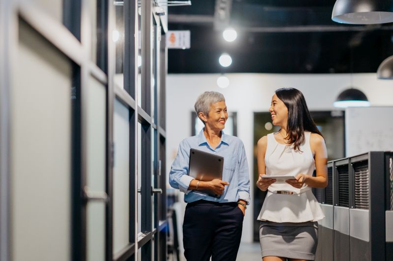 Two women walking through an office hallway
