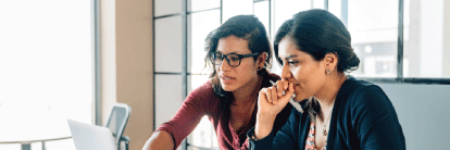 Employees discussing in front of a laptop