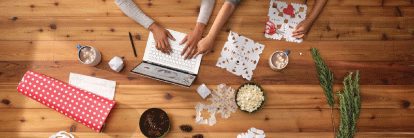 Employee working on a laptop surrounded by paper products