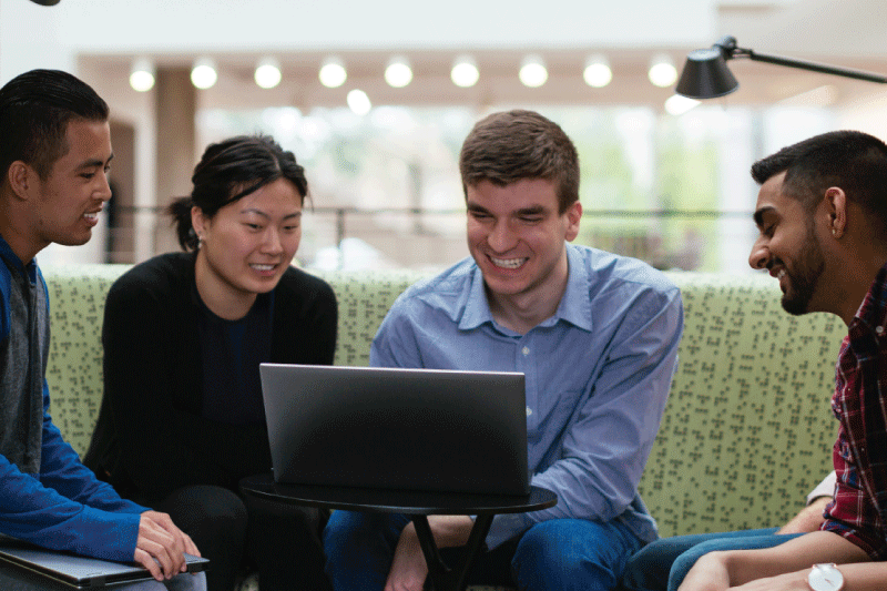 Four employees looking at a screen.